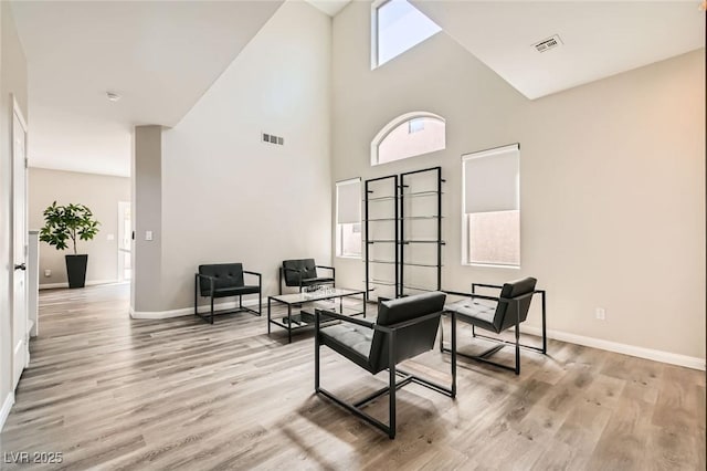 8469 Cheerful Brook Ave, Las Vegas, NV 89143 - sitting room with a high ceiling, baseboards, and light wood-style floors