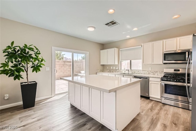 8469 Cheerful Brook Ave, Las Vegas, NV 89143 - kitchen featuring appliances with stainless steel finishes, a sink, light countertops, white cabinets, and light wood-type flooring