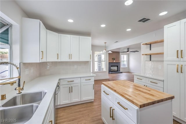 2107 Fountain Springs Dr, Henderson, NV 89074 - kitchen with butcher block countertops, a sink, a ceiling fan, light wood-style flooring, and tasteful backsplash