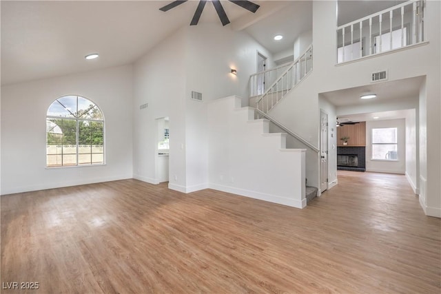 2107 Fountain Springs Dr, Henderson, NV 89074 - unfurnished living room featuring a ceiling fan, high vaulted ceiling, light wood-style floors, healthy amount of natural light, and beam ceiling