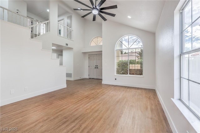 2107 Fountain Springs Dr, Henderson, NV 89074 - unfurnished living room featuring a ceiling fan, light wood finished floors, baseboards, and a towering ceiling