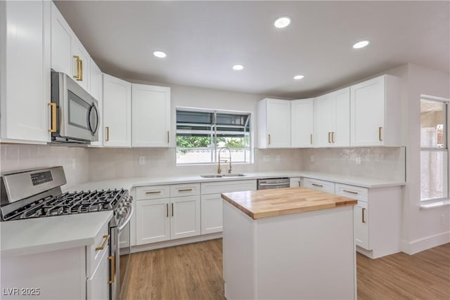 2107 Fountain Springs Dr, Henderson, NV 89074 - kitchen with stainless steel appliances, a sink, wooden counters, light wood-style floors, and white cabinetry