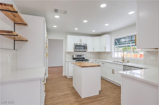 2107 Fountain Springs Dr, Henderson, NV 89074 - kitchen with stainless steel appliances, a sink, open shelves, wood counters, and decorative backsplash