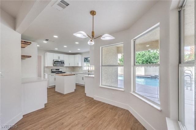 2107 Fountain Springs Dr, Henderson, NV 89074 - kitchen featuring appliances with stainless steel finishes, white cabinets, light wood-type flooring, decorative backsplash, and recessed lighting