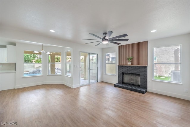 2107 Fountain Springs Dr, Henderson, NV 89074 - unfurnished living room featuring a ceiling fan, light wood finished floors, a brick fireplace, baseboards, and recessed lighting