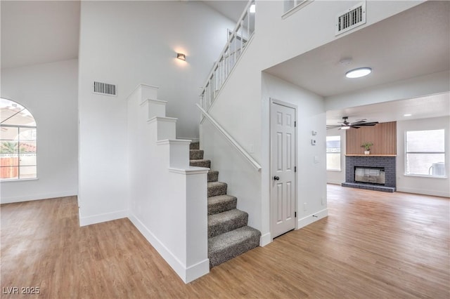 2107 Fountain Springs Dr, Henderson, NV 89074 - stairs featuring wood finished floors, baseboards, a towering ceiling, ceiling fan, and a fireplace