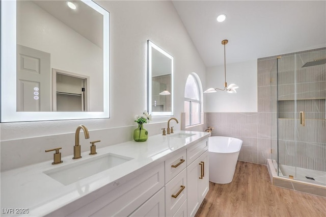 2107 Fountain Springs Dr, Henderson, NV 89074 - full bathroom featuring a shower stall, tile walls, double vanity, a soaking tub, and wood finished floors