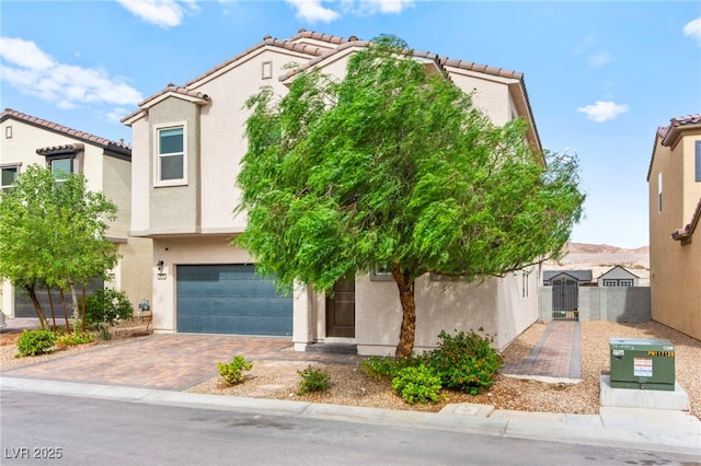 2672 Painted Mist Ct, Las Vegas, NV 89142 - view of front of home featuring a garage, a tiled roof, stucco siding, and decorative driveway