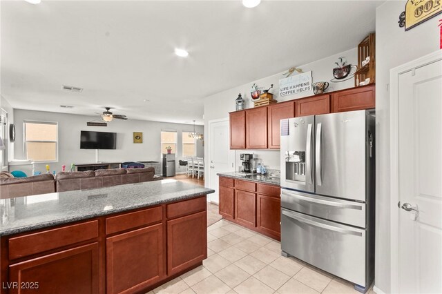 2672 Painted Mist Ct, Las Vegas, NV 89142 - kitchen with stainless steel refrigerator with ice dispenser, light tile patterned floors, ceiling fan, dark stone counters, and open floor plan