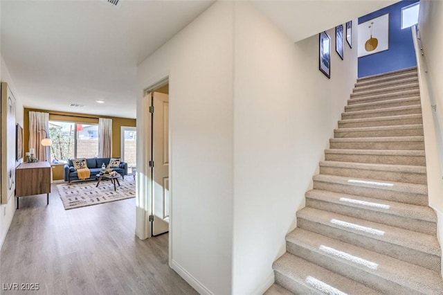 stairs featuring wood finished floors and baseboards