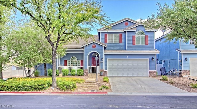 view of front facade featuring driveway, an attached garage, and a porch