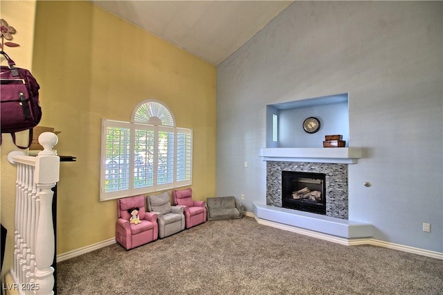 living area with carpet, a tiled fireplace, high vaulted ceiling, and baseboards