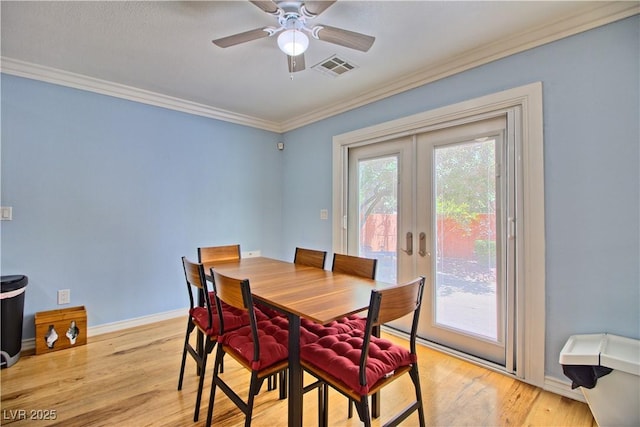 dining room featuring crown molding, french doors, light wood finished floors, baseboards, and a ceiling fan