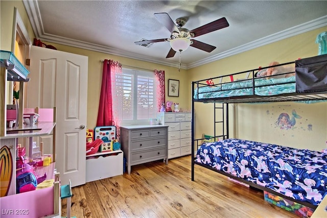 bedroom with crown molding, light wood-style floors, a textured ceiling, and a ceiling fan