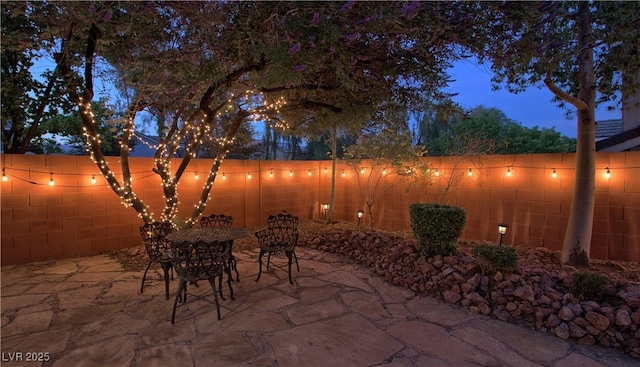 7728 Whispering River St, Las Vegas, NV 89131 - patio at twilight featuring a patio area, a fenced backyard, and outdoor dining area