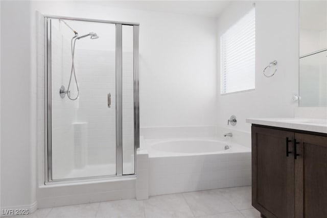 bathroom with a shower stall, vanity, a garden tub, and tile patterned floors