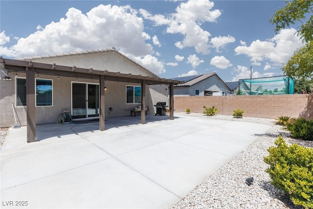 back of property with stucco siding, fence, and a patio area