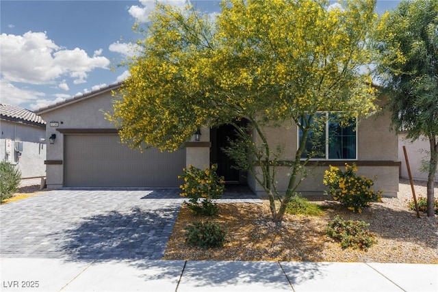 view of front of property with stucco siding, a garage, and decorative driveway