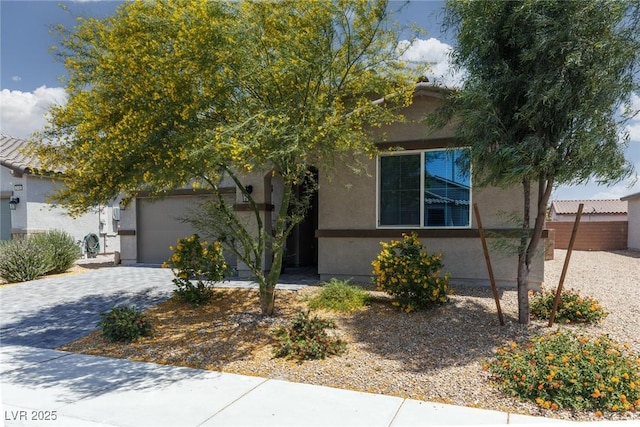 obstructed view of property featuring a garage, stucco siding, and driveway
