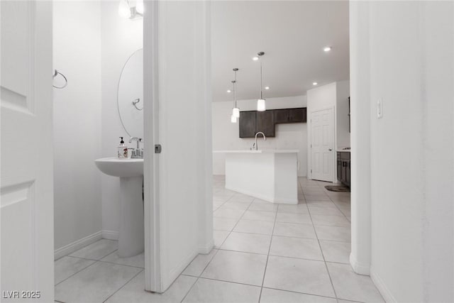 bathroom featuring a sink, tile patterned floors, baseboards, and recessed lighting