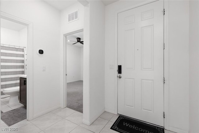 entryway with light tile patterned flooring, baseboards, and ceiling fan