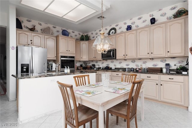 3522 Shonna Way N, Las Vegas, NV 89032 - kitchen featuring appliances with stainless steel finishes, a center island with sink, hanging light fixtures, dark stone countertops, and light tile patterned floors