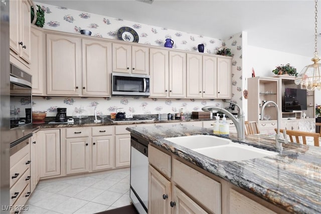 3522 Shonna Way N, Las Vegas, NV 89032 - kitchen with appliances with stainless steel finishes, wallpapered walls, pendant lighting, dark stone countertops, and cream cabinets