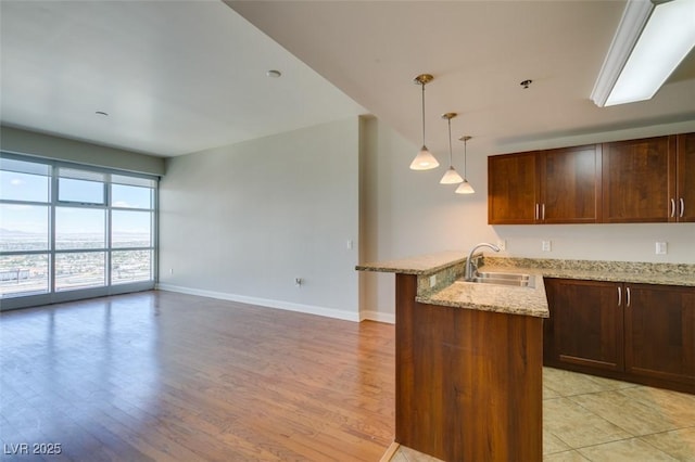 150 Las Vegas Blvd Unit 2003, Las Vegas, NV 89101 - kitchen with a sink, baseboards, a peninsula, and light wood-style floors
