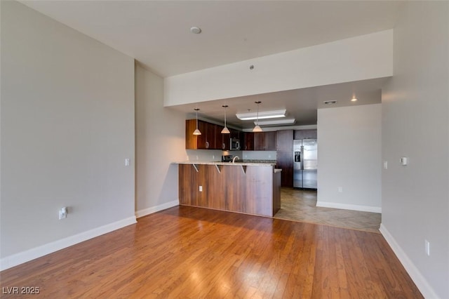 150 Las Vegas Blvd Unit 2003, Las Vegas, NV 89101 - kitchen with stainless steel appliances, a peninsula, light wood-type flooring, light countertops, and a breakfast bar