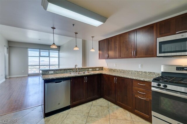 150 Las Vegas Blvd Unit 2003, Las Vegas, NV 89101 - kitchen with stainless steel appliances, a sink, light stone counters, a peninsula, and dark brown cabinets
