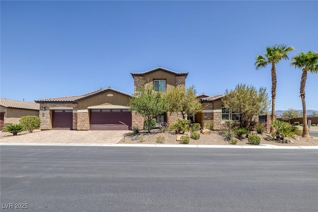 11088 Westcroft Way, Las Vegas, NV 89183 - view of front of property with stucco siding, stone siding, a tile roof, an attached garage, and driveway