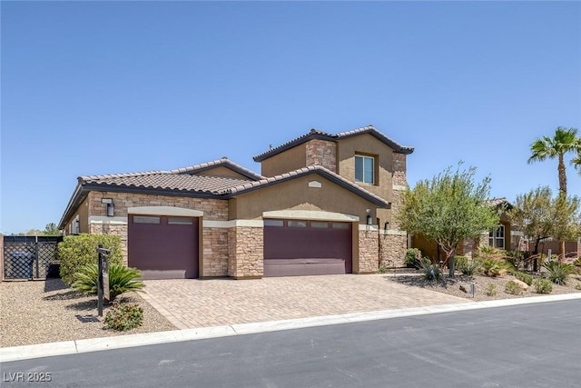 11088 Westcroft Way, Las Vegas, NV 89183 - view of front facade featuring stone siding, an attached garage, stucco siding, decorative driveway, and a tiled roof