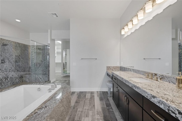 11088 Westcroft Way, Las Vegas, NV 89183 - bathroom featuring vanity, a shower stall, a garden tub, baseboards, and wood finished floors