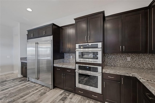 11088 Westcroft Way, Las Vegas, NV 89183 - kitchen with stainless steel appliances, light wood-style flooring, tasteful backsplash, dark brown cabinetry, and recessed lighting