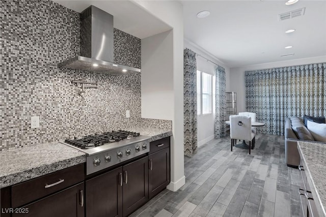 11088 Westcroft Way, Las Vegas, NV 89183 - kitchen with wall chimney exhaust hood, stainless steel gas stovetop, backsplash, baseboards, and dark brown cabinets