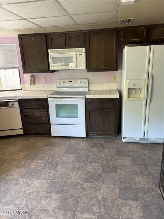 2100 Plaza Del Padre, Las Vegas, NV 89102 - kitchen with white appliances, tile countertops, dark brown cabinets, and a drop ceiling