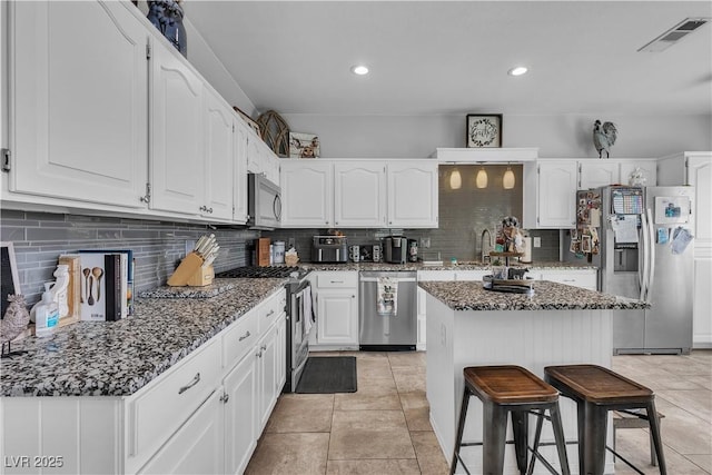 7929 Ben Hogan Dr, Las Vegas, NV 89149 - kitchen featuring appliances with stainless steel finishes, white cabinets, decorative backsplash, and recessed lighting