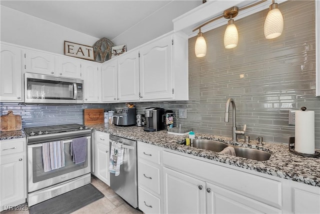 7929 Ben Hogan Dr, Las Vegas, NV 89149 - kitchen featuring appliances with stainless steel finishes, a sink, tasteful backsplash, dark stone countertops, and white cabinets