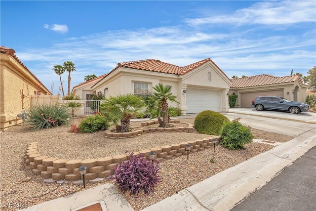 7929 Ben Hogan Dr, Las Vegas, NV 89149 - mediterranean / spanish-style home with an attached garage, concrete driveway, stucco siding, a tiled roof, and fence