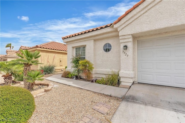 7929 Ben Hogan Dr, Las Vegas, NV 89149 - doorway to property featuring stucco siding, a tile roof, and an attached garage
