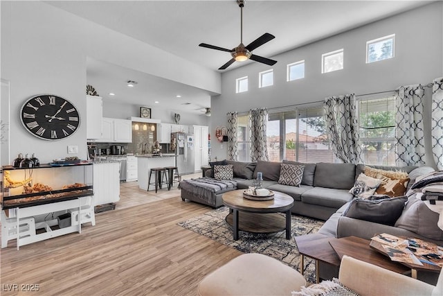 7929 Ben Hogan Dr, Las Vegas, NV 89149 - living room with ceiling fan, light wood-style flooring, and a high ceiling