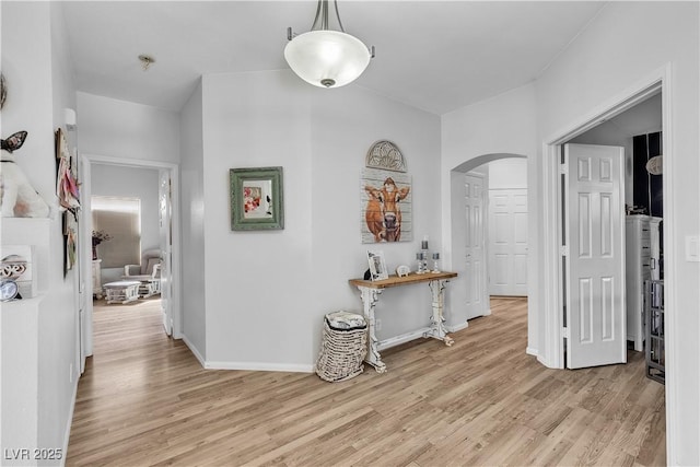 7929 Ben Hogan Dr, Las Vegas, NV 89149 - hallway featuring arched walkways, light wood-style floors, and baseboards