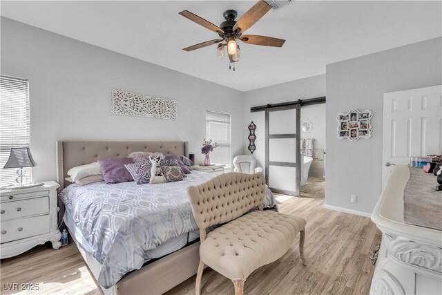 7929 Ben Hogan Dr, Las Vegas, NV 89149 - bedroom with a barn door, light wood-style flooring, baseboards, and a ceiling fan