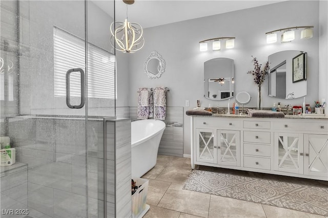 7929 Ben Hogan Dr, Las Vegas, NV 89149 - bathroom featuring a stall shower, a freestanding tub, double vanity, a chandelier, and ceiling fan