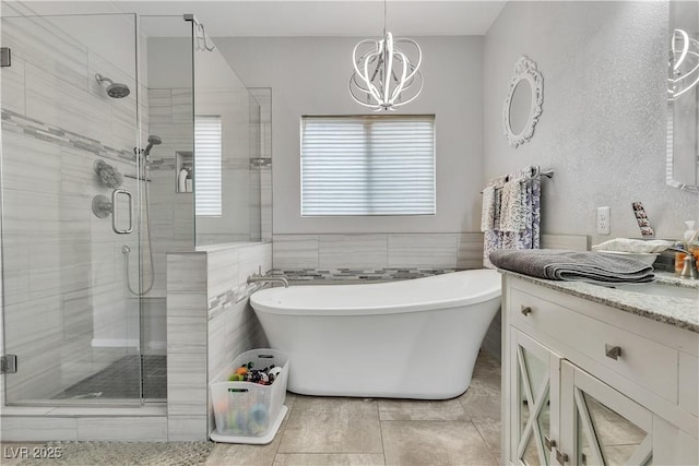 7929 Ben Hogan Dr, Las Vegas, NV 89149 - bathroom with a chandelier, a stall shower, a soaking tub, vanity, and tile walls