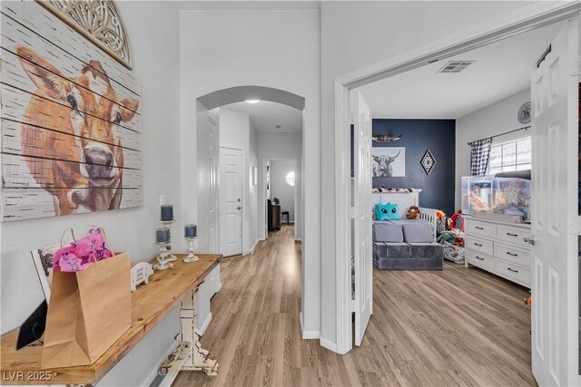7929 Ben Hogan Dr, Las Vegas, NV 89149 - hall featuring arched walkways, light wood-style floors, and baseboards