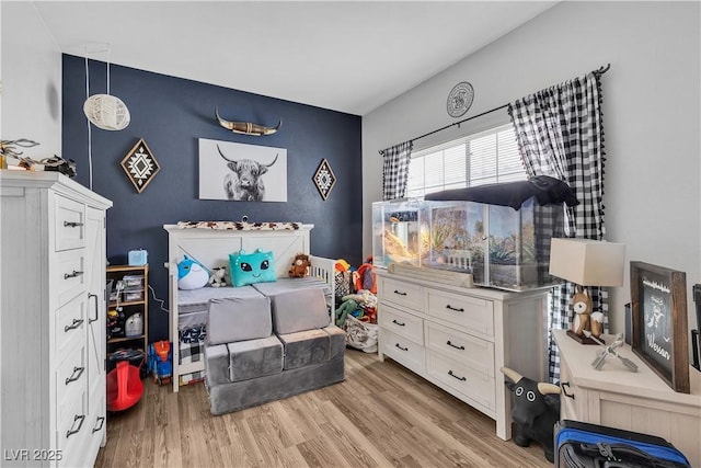7929 Ben Hogan Dr, Las Vegas, NV 89149 - bedroom featuring an accent wall and light wood-style flooring