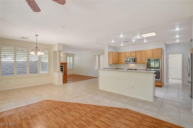 10302 Cara Mia Ct, Las Vegas, NV 89135 - kitchen featuring appliances with stainless steel finishes, a ceiling fan, light tile patterned floors, open floor plan, and hanging light fixtures
