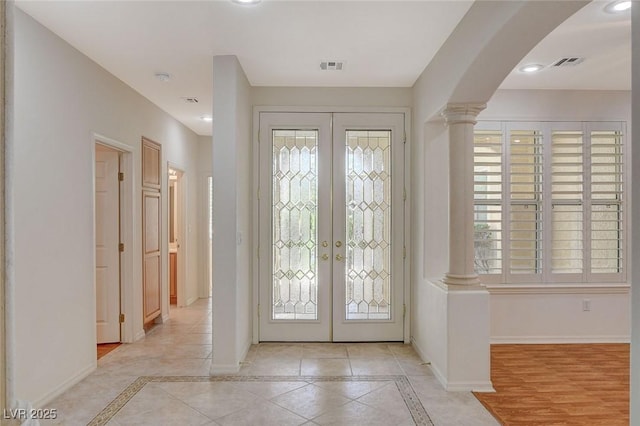 10302 Cara Mia Ct, Las Vegas, NV 89135 - foyer entrance featuring french doors, ornate columns, arched walkways, inlaid floor details, and recessed lighting