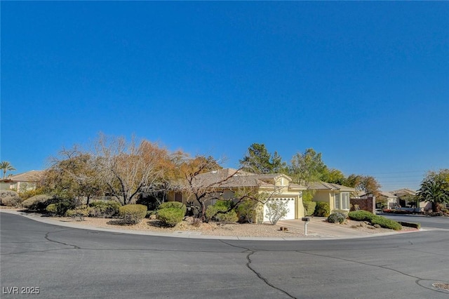 10302 Cara Mia Ct, Las Vegas, NV 89135 - obstructed view of property featuring a residential view, an attached garage, concrete driveway, and stucco siding